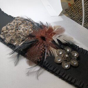 A hand made black stretch belt created in a rich wild animal motief.